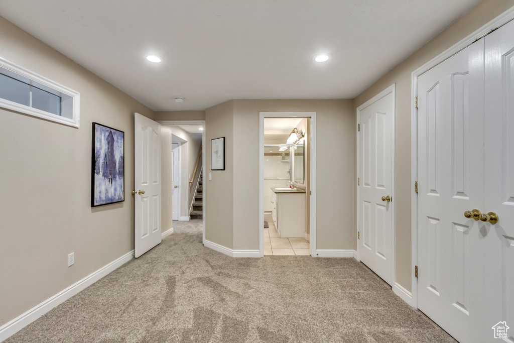 Unfurnished bedroom featuring light colored carpet, recessed lighting, and ensuite bathroom