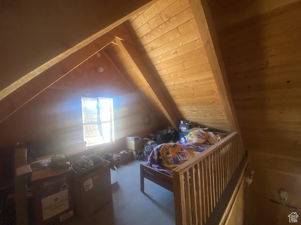 Additional living space with lofted ceiling and wooden walls