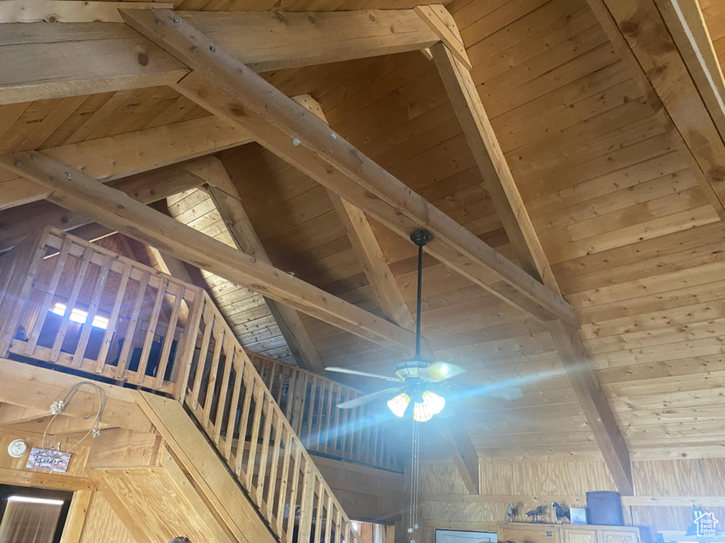Detailed view of a wood ceiling with exposed beams and ceiling fan