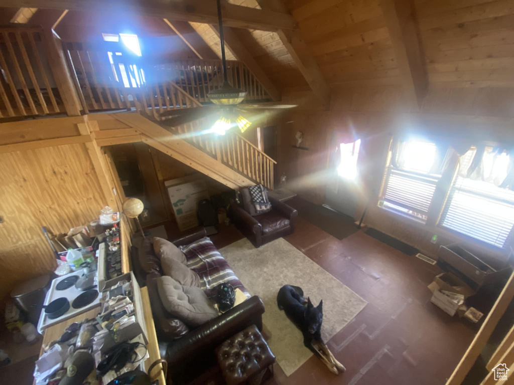 Living room with beam ceiling and wood walls