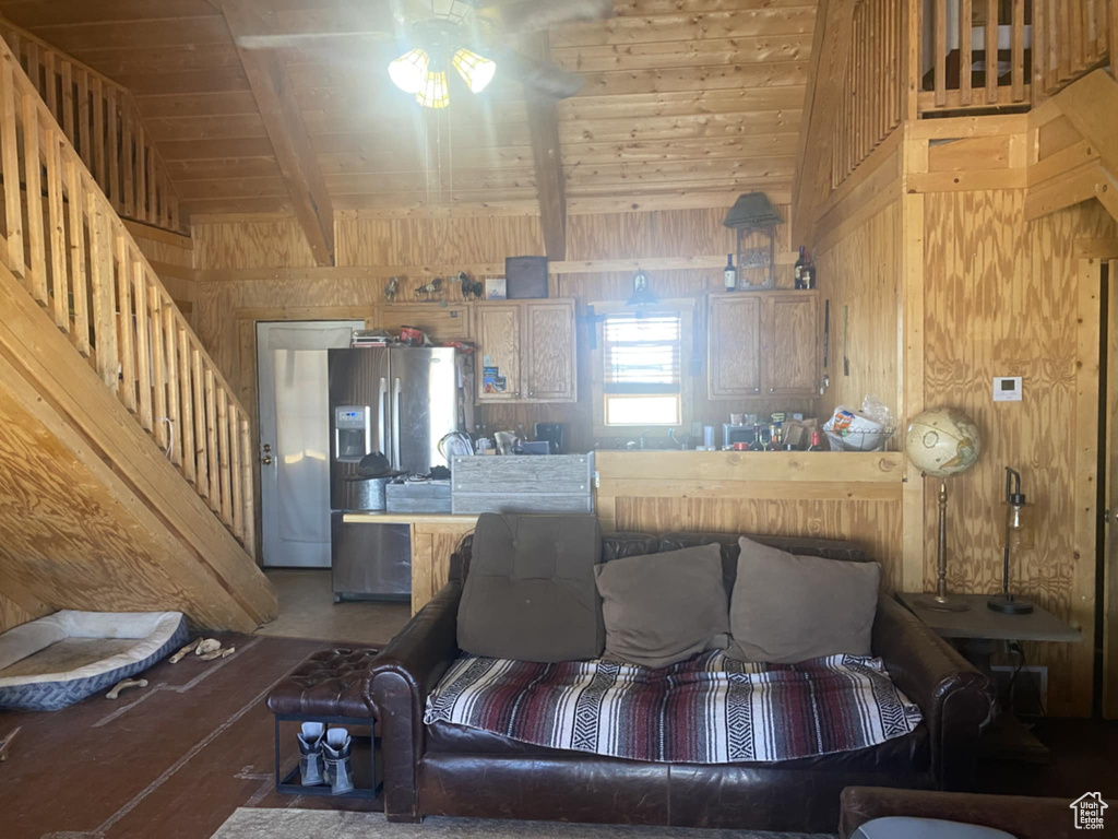 Living area with wooden walls, a ceiling fan, and wooden ceiling