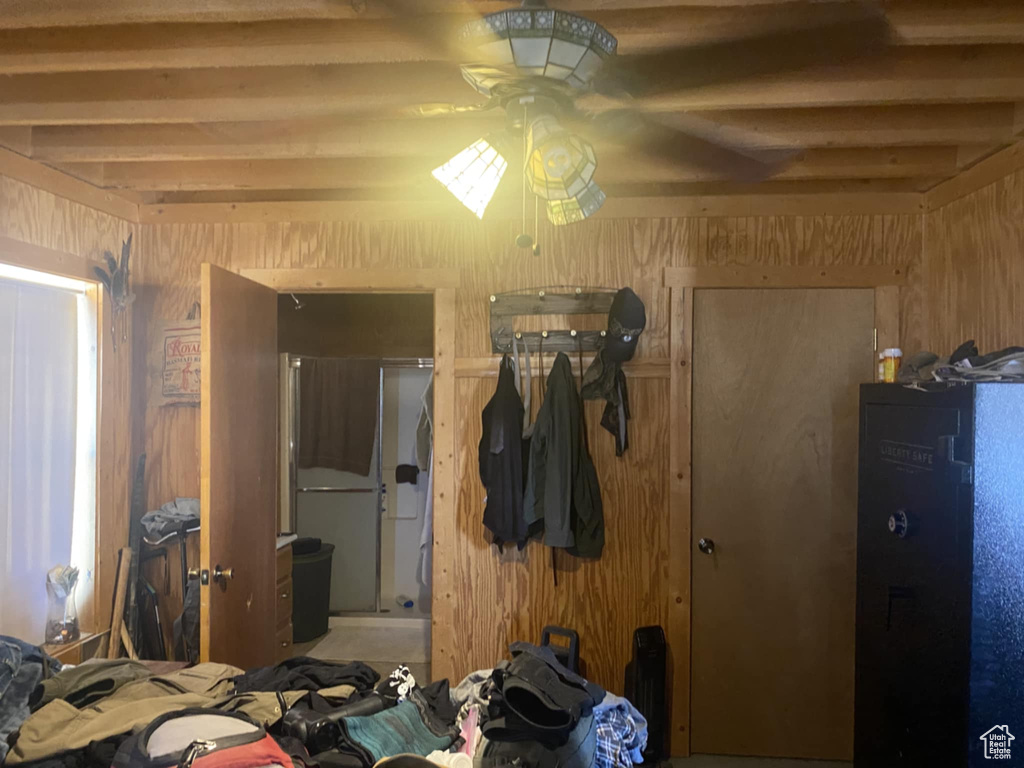 Bedroom featuring wood walls and beamed ceiling