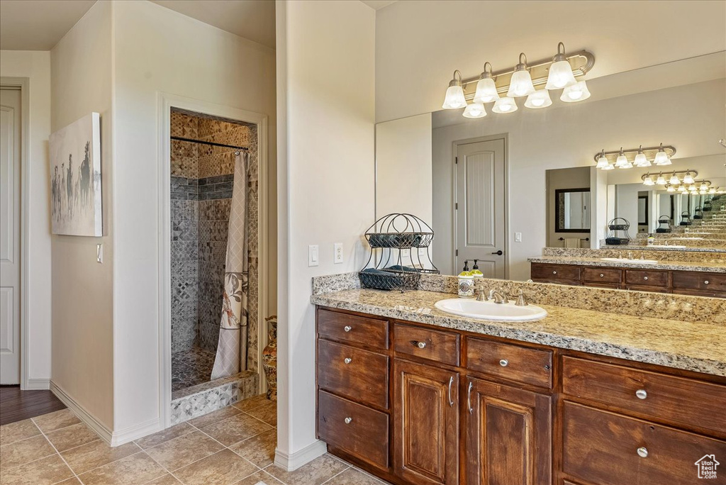 Full bathroom featuring a shower stall, vanity, and tile patterned flooring