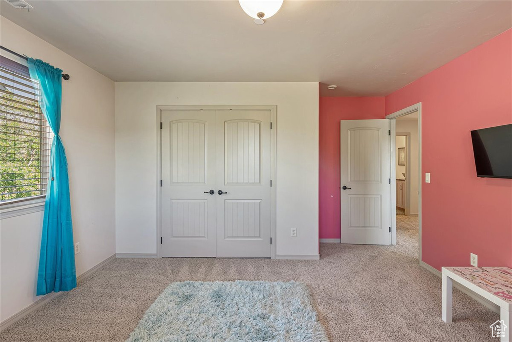 Unfurnished bedroom featuring carpet floors and a closet