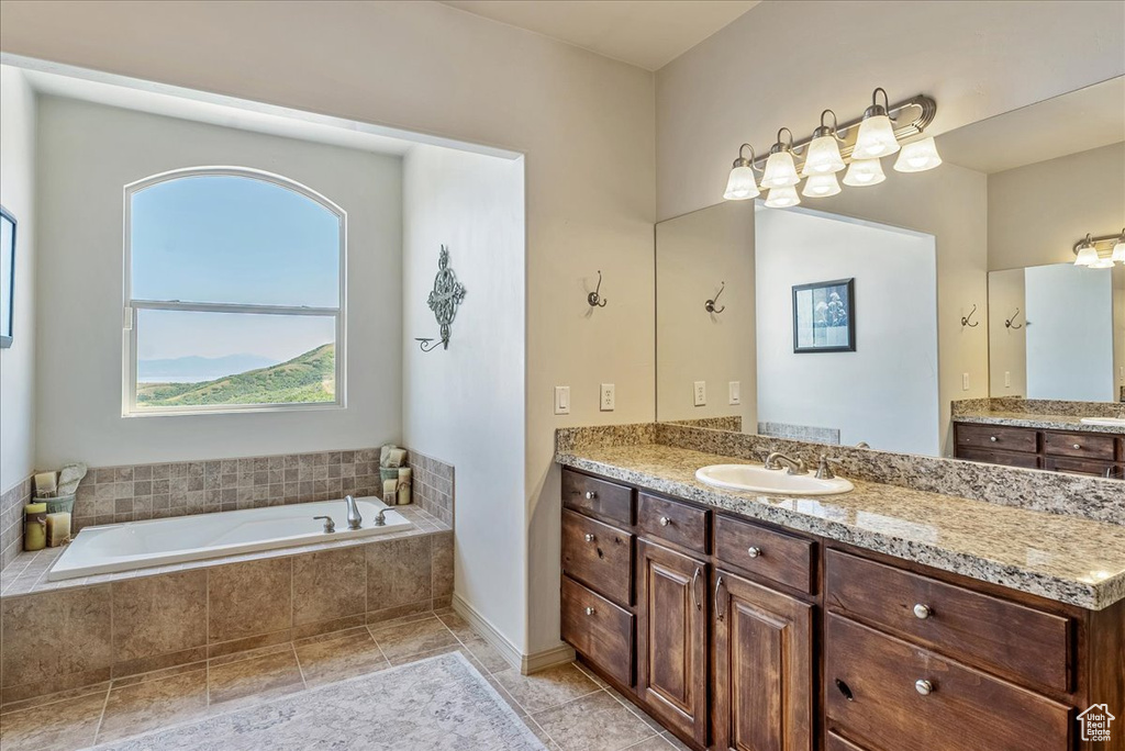 Bathroom with a bath, vanity, plenty of natural light, and tile patterned flooring