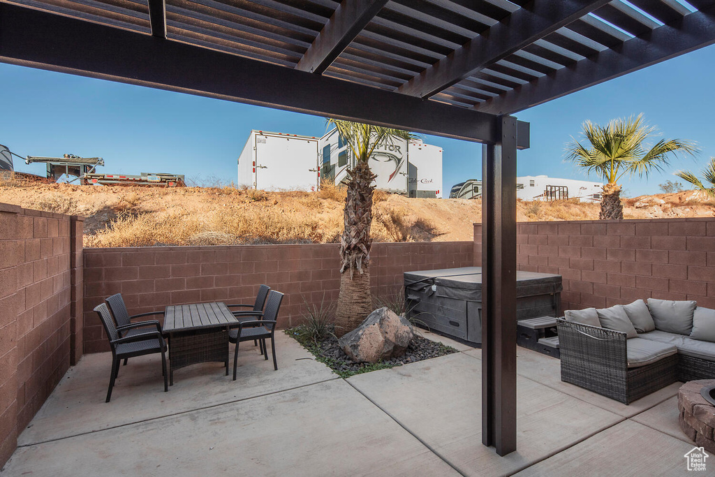 Fenced backyard with a hot tub, a patio area, outdoor dining space, and outdoor lounge area