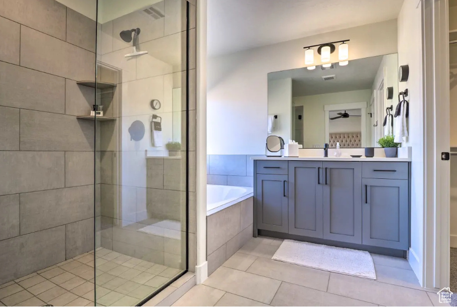 Bathroom with a tile shower, a garden tub, vanity, tile patterned floors, and a ceiling fan