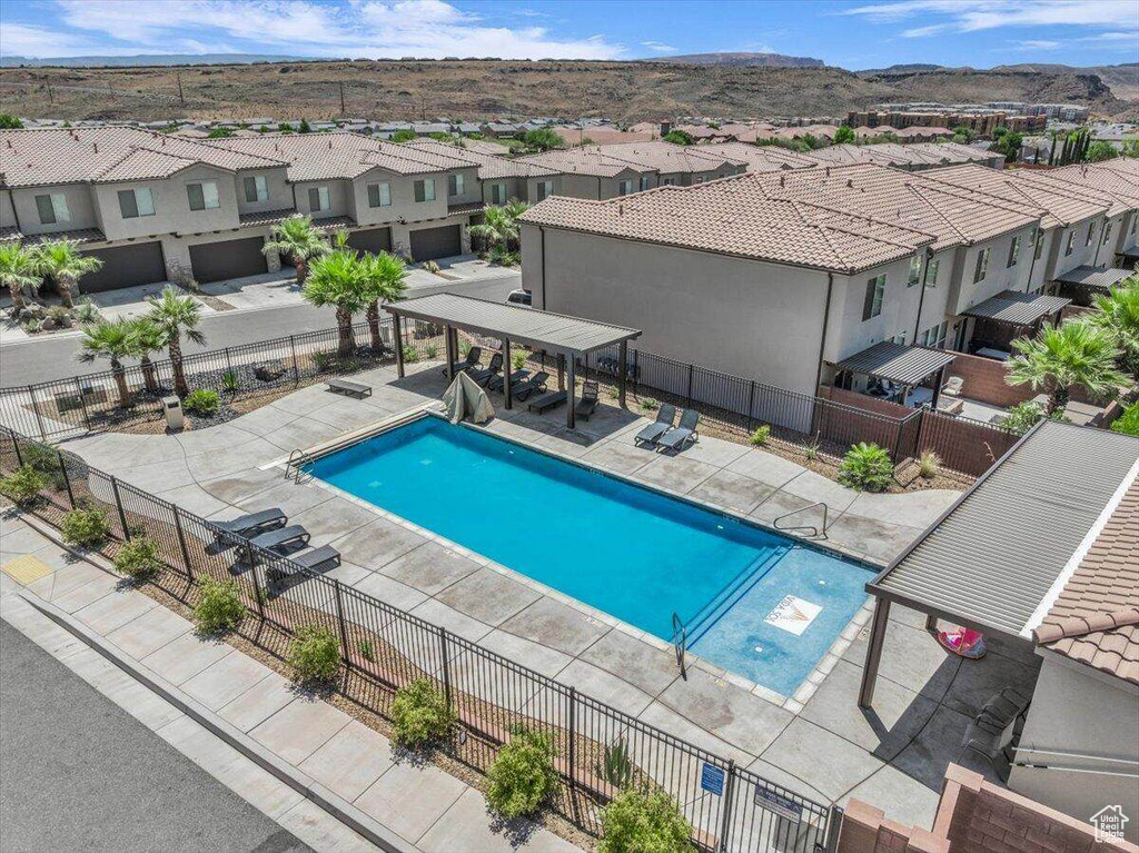 Community pool featuring a residential view, a mountain view, and a patio