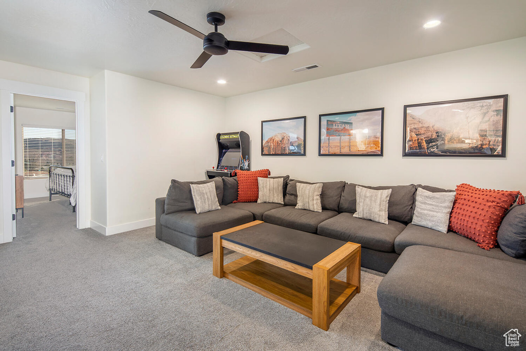 Carpeted living area with recessed lighting and a ceiling fan