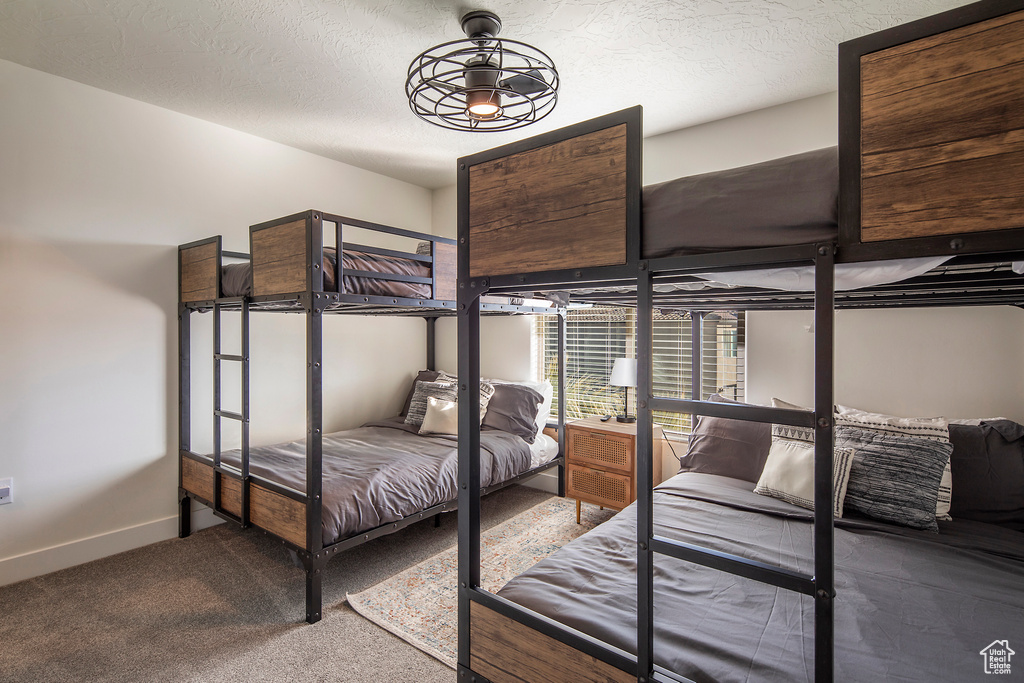 Bedroom featuring carpet and a textured ceiling