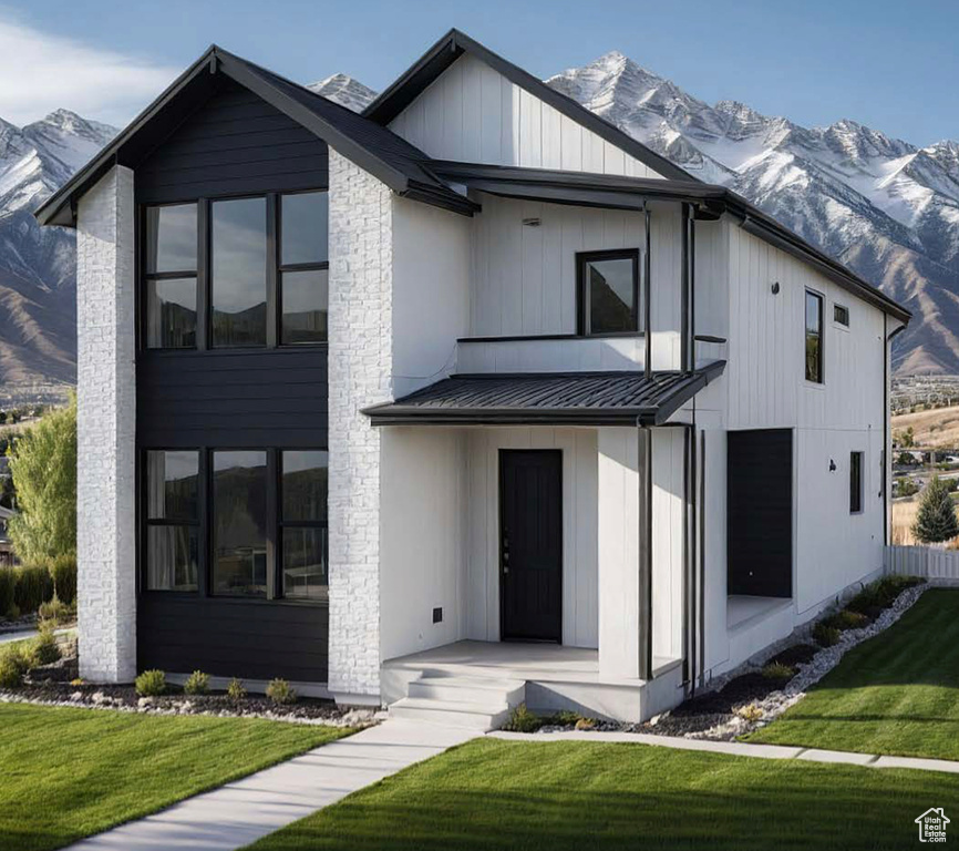 Modern inspired farmhouse with a mountain view, a standing seam roof, and a front yard