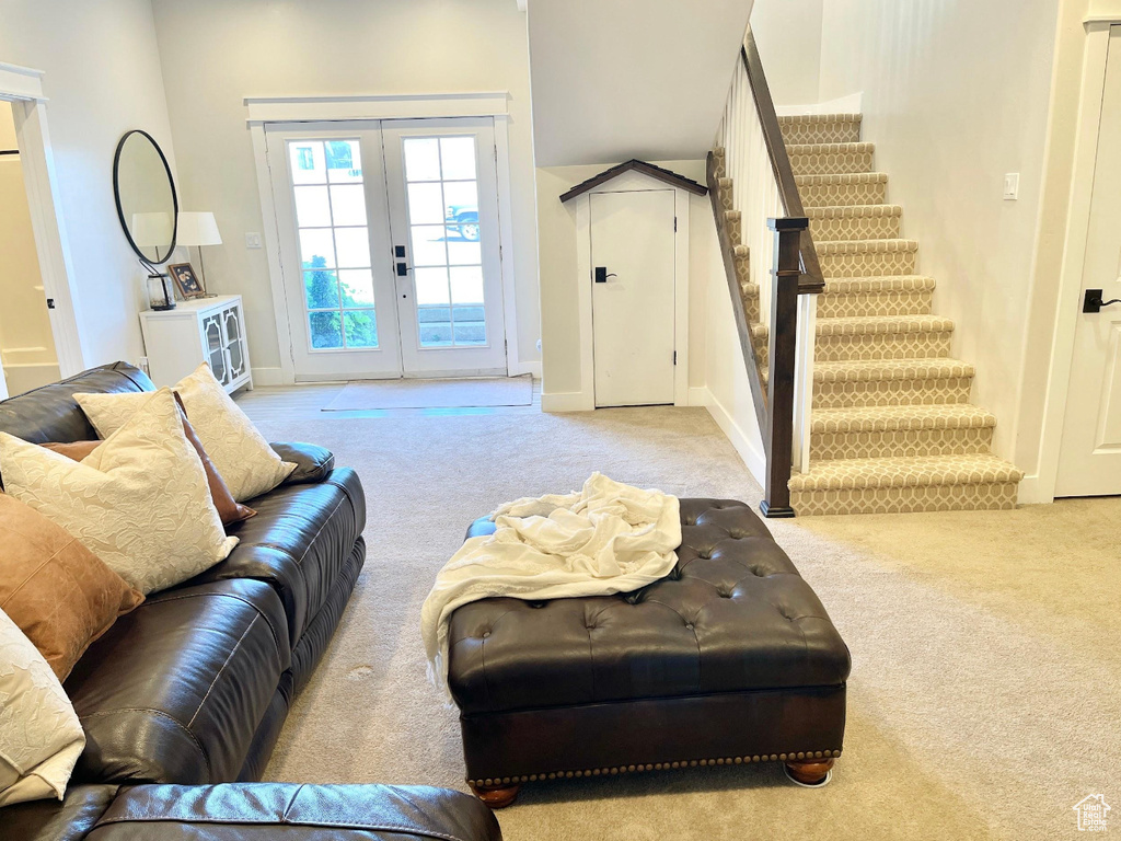 Living room featuring light colored carpet, stairway, and french doors