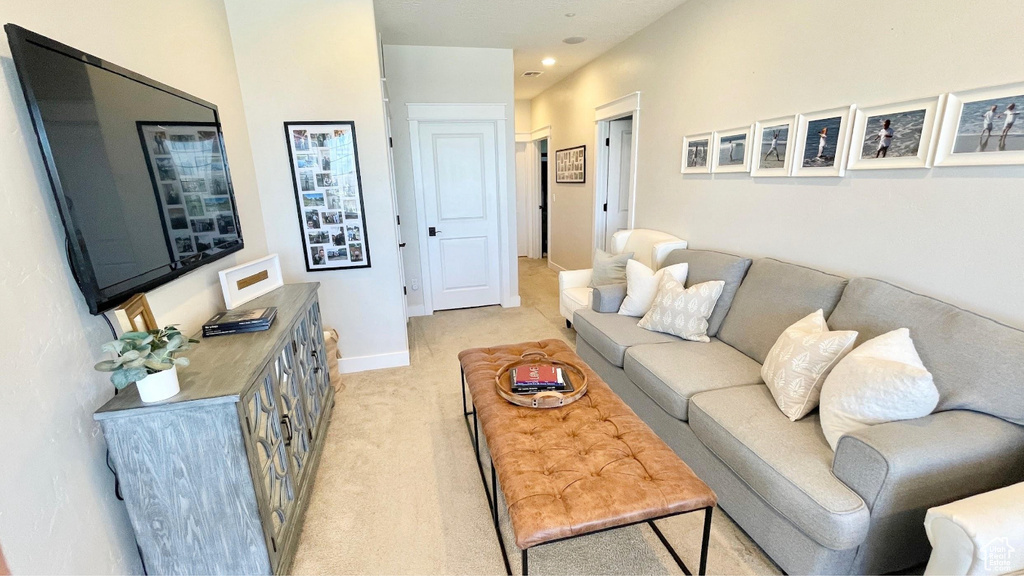 Living area with light colored carpet and recessed lighting