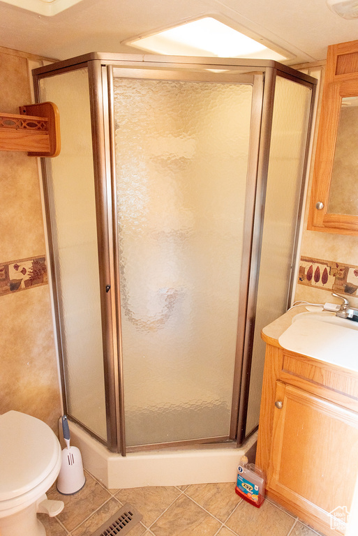 Full bathroom with vanity, a shower stall, and tile patterned flooring