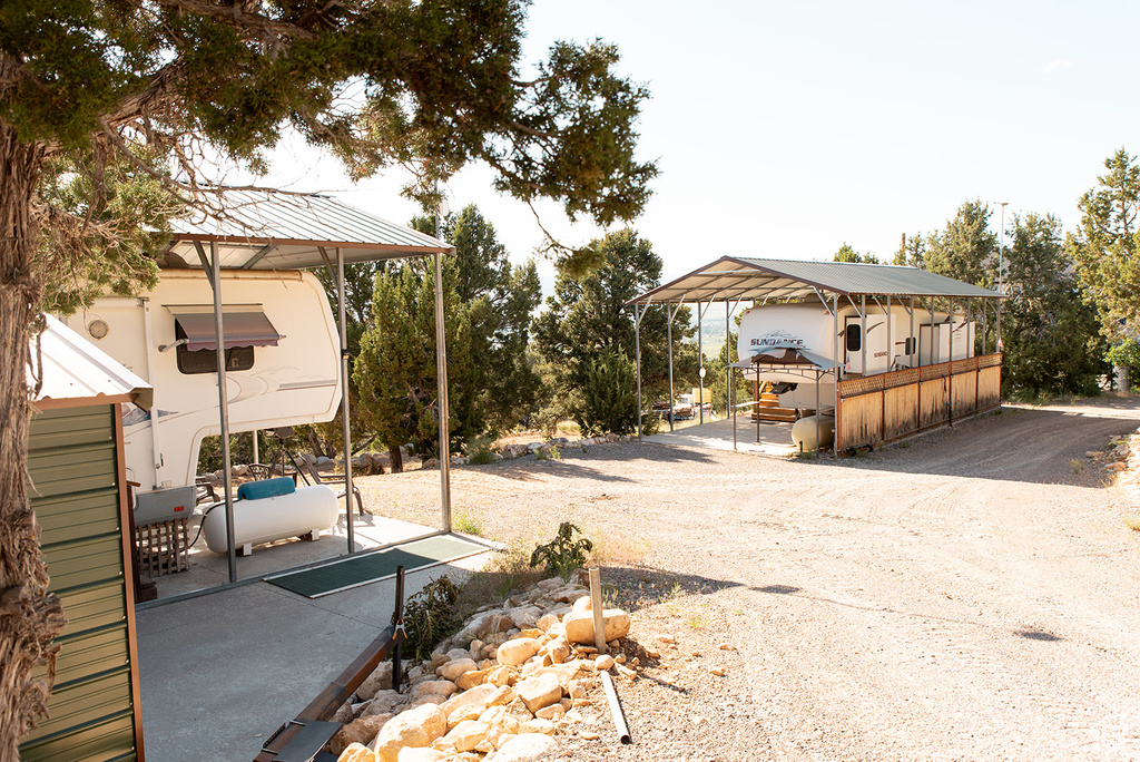 View of yard with a carport and driveway