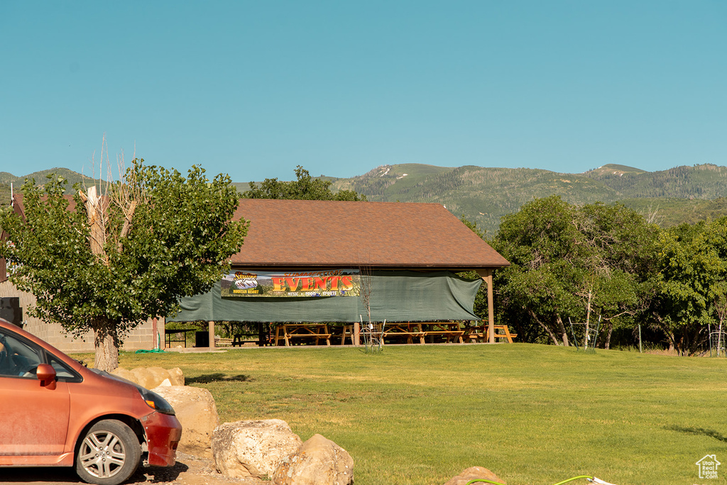 View of front of home featuring a mountain view and a front lawn