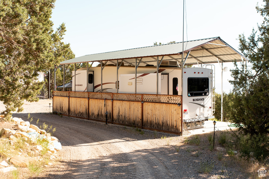 View of front of house with a detached carport and a metal roof