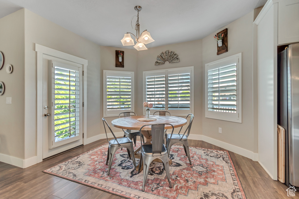 Dining space with wood finished floors and a chandelier