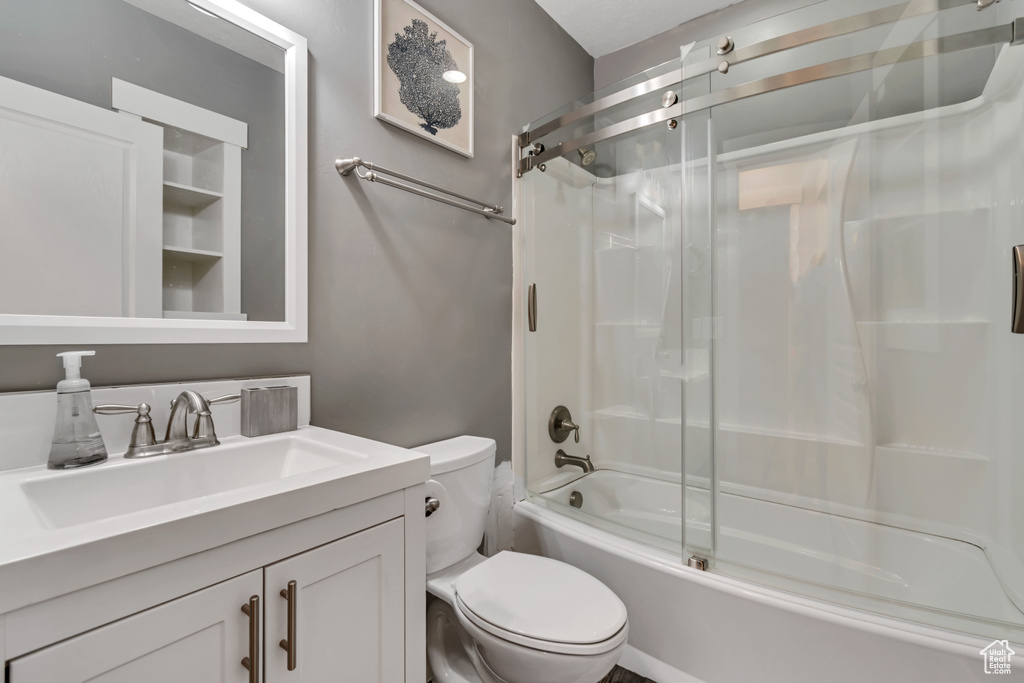 Bathroom with combined bath / shower with glass door and vanity