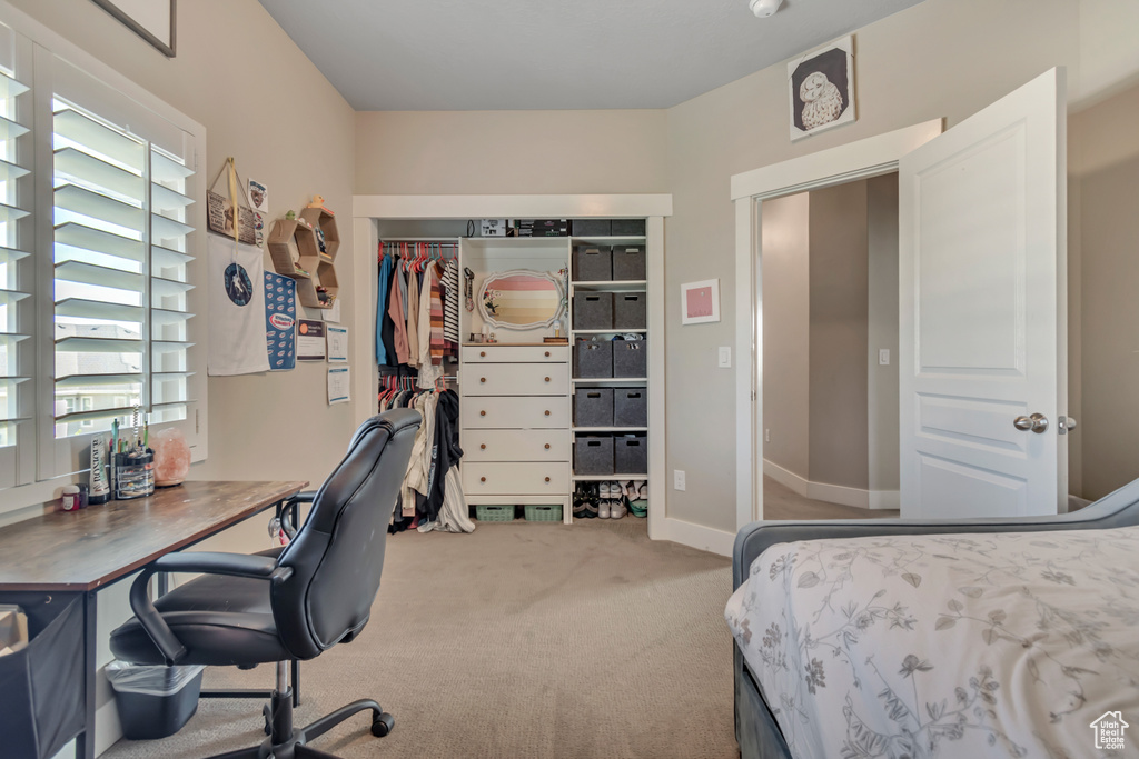 Bedroom featuring carpet floors, an office area, and a closet