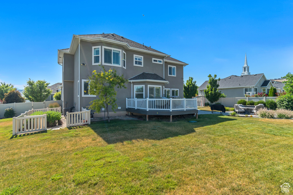 Rear view of property with a wooden deck, a fenced backyard, and stucco siding