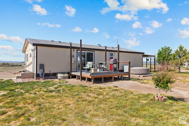 Rear view of property with a deck and a yard