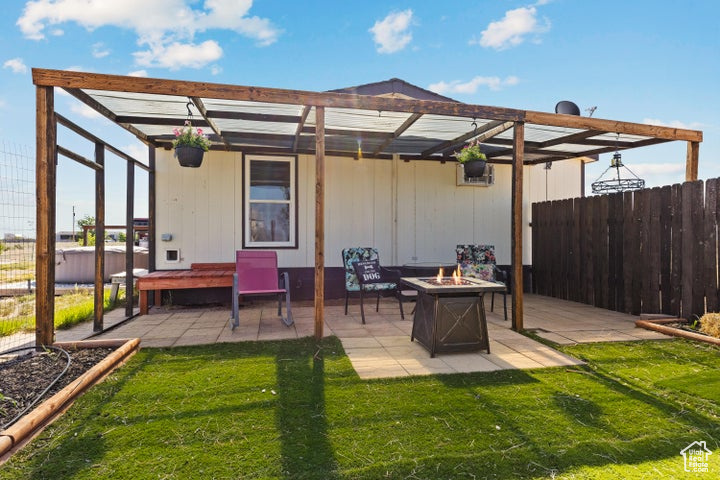 View of patio / terrace with an outdoor fire pit and a hot tub