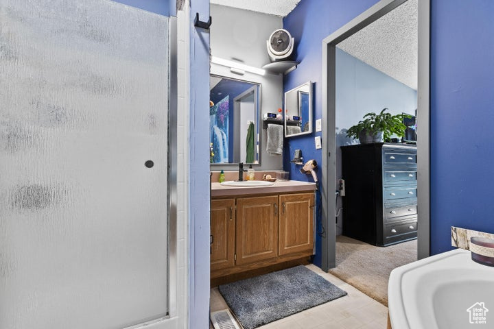 Full bathroom featuring a shower stall and vanity