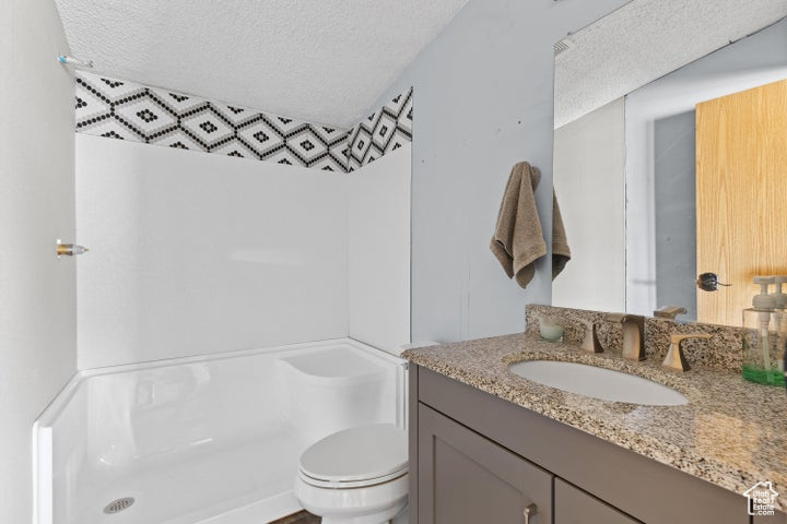 Bathroom featuring vanity, a textured ceiling, and a shower