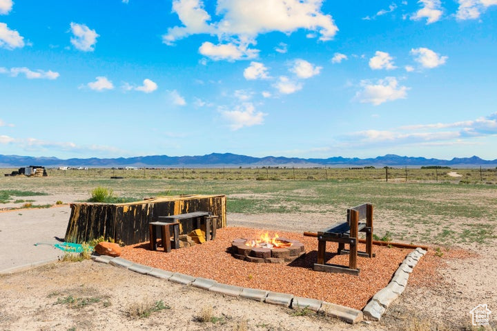 View of yard featuring a fire pit, a rural view, and a mountain view