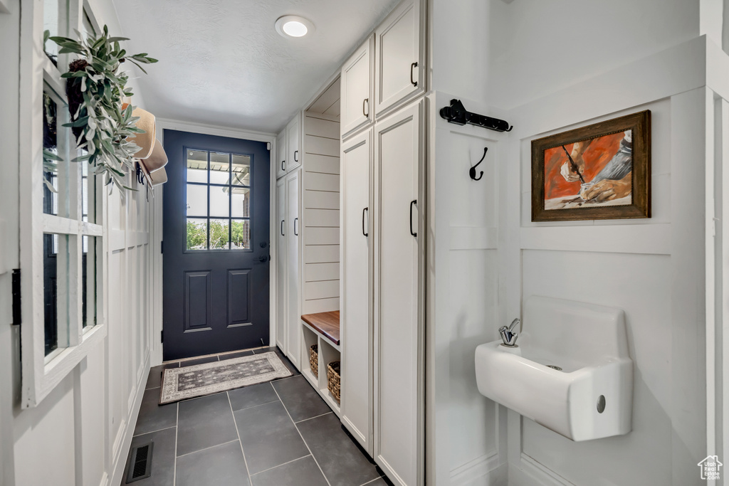 Mudroom with dark tile patterned flooring