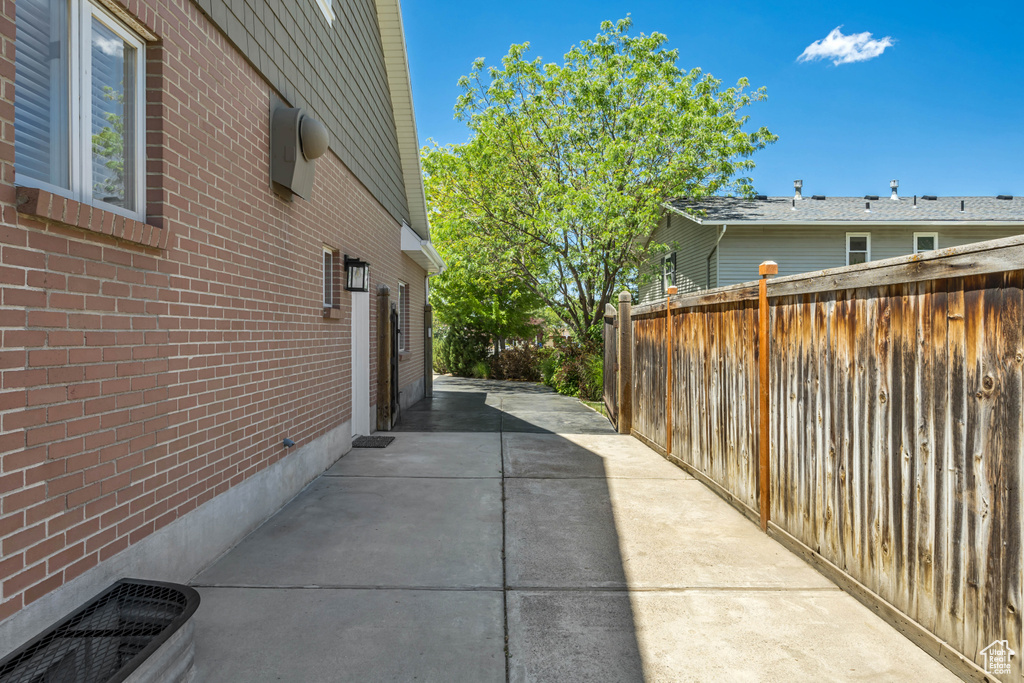 View of property exterior with a patio area and brick siding