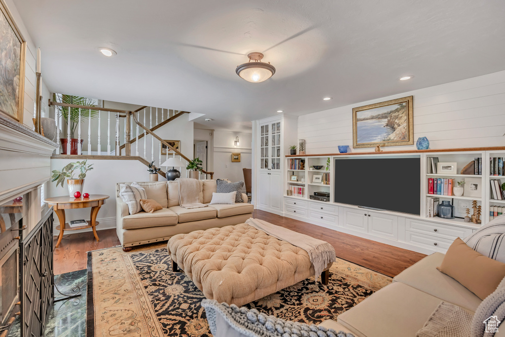 Living area featuring wood finished floors, stairway, a fireplace, and recessed lighting