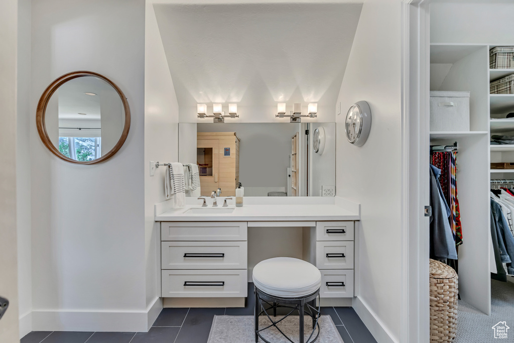 Bathroom featuring tile patterned floors, vanity, and a spacious closet