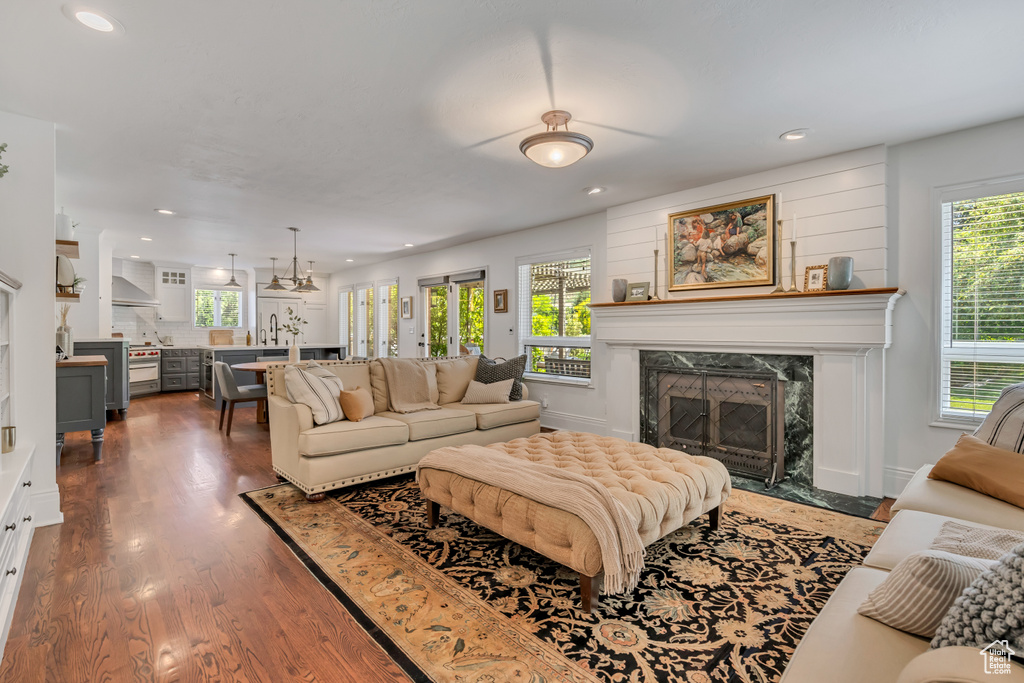 Living area with recessed lighting, a fireplace, and dark wood-style flooring