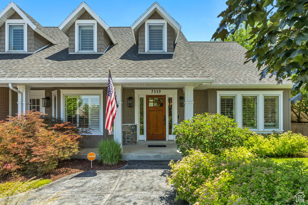 Cape cod house with roof with shingles and covered porch