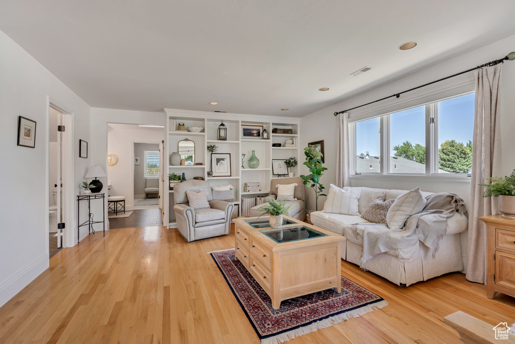 Living room with light wood-style floors and recessed lighting