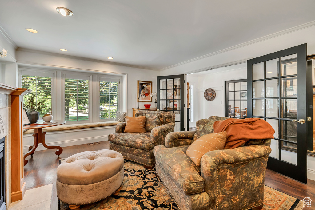 Living room featuring a high end fireplace, ornamental molding, wood finished floors, french doors, and recessed lighting