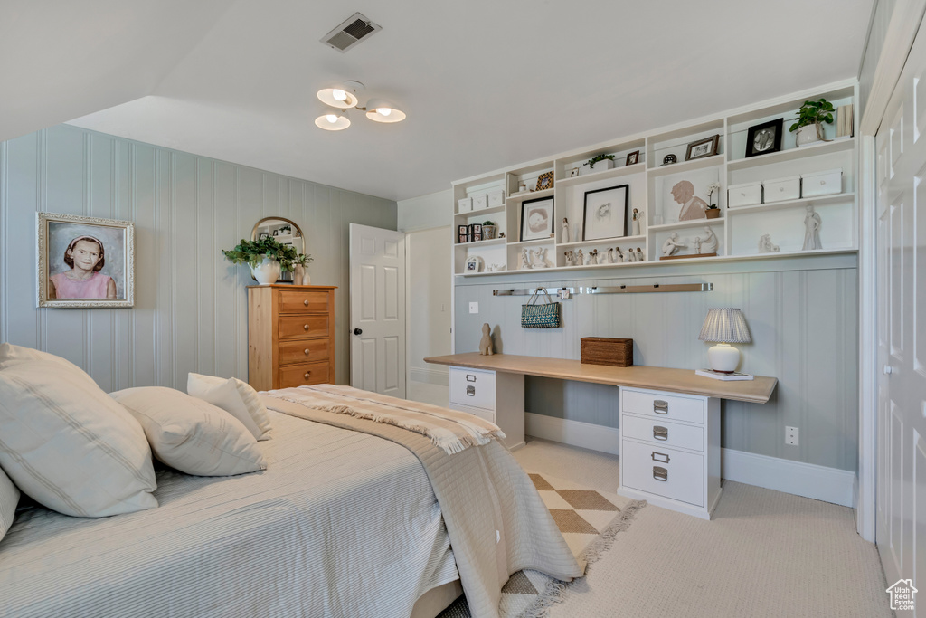 Bedroom featuring light carpet and an office area