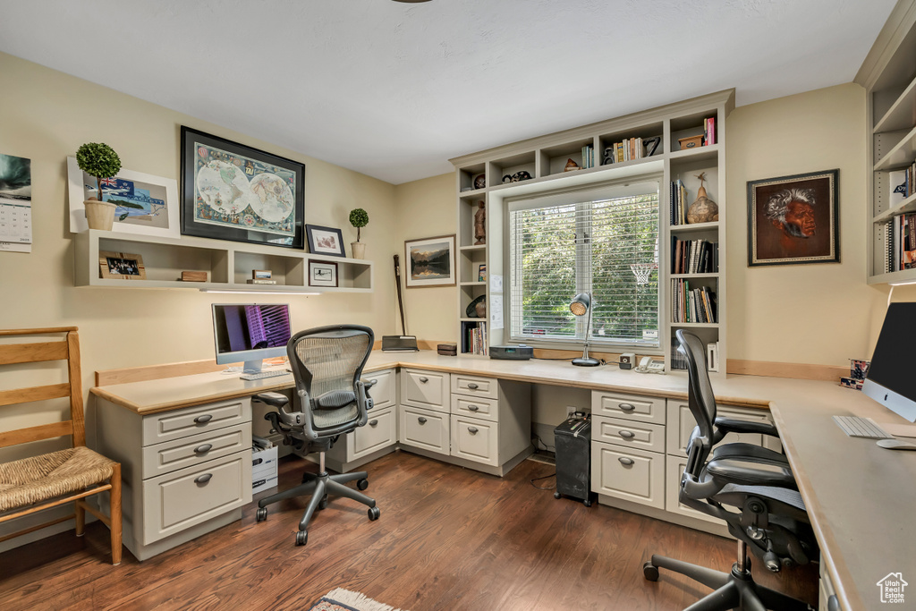 Office space featuring dark wood-style floors and built in desk