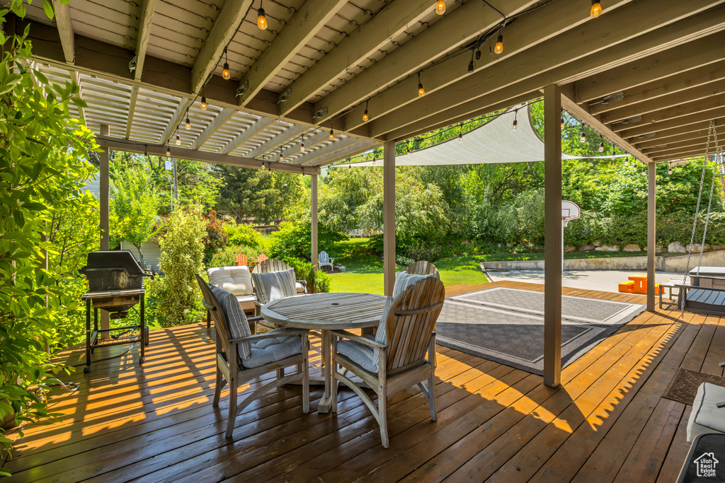 Deck featuring outdoor dining space and a pergola