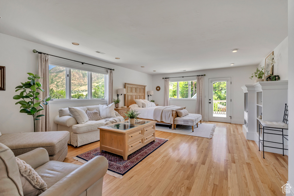 Living area with light wood-type flooring and healthy amount of natural light
