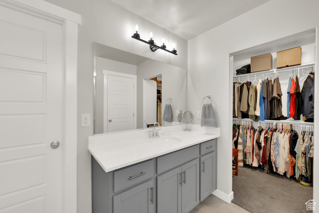 Bathroom featuring vanity and a walk in closet