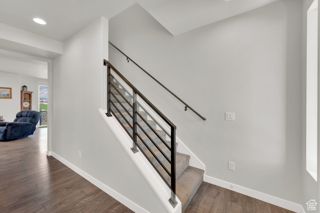 Stairs featuring wood finished floors and recessed lighting