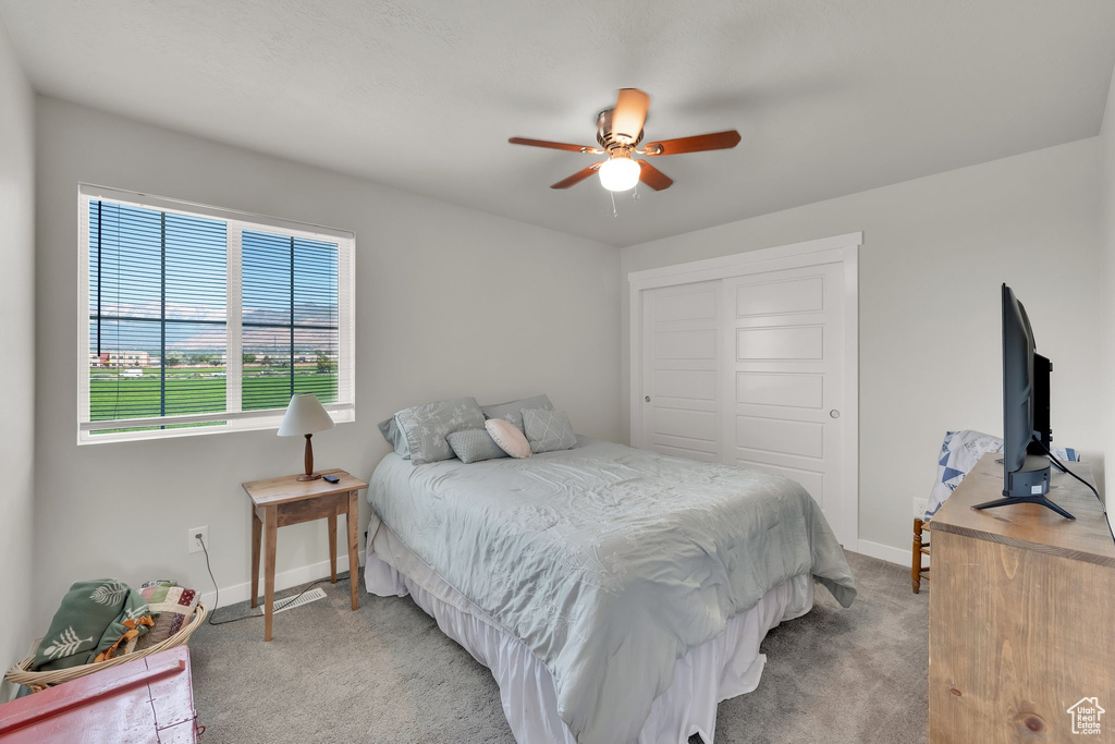 Bedroom with carpet floors, a closet, and ceiling fan