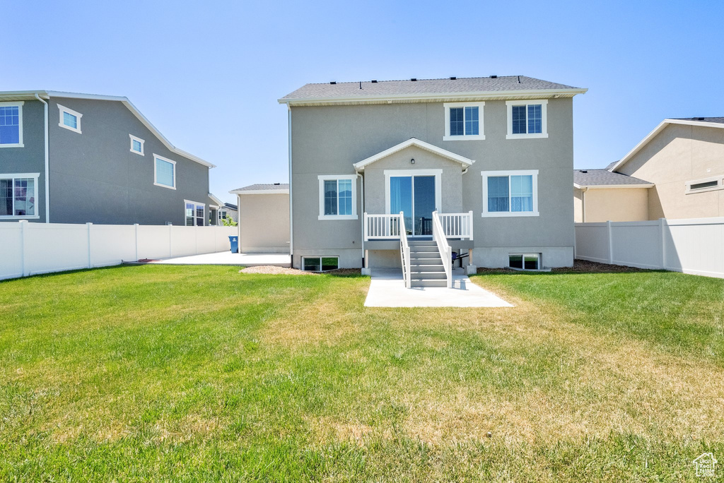 Back of house with a fenced backyard, a patio area, and stucco siding