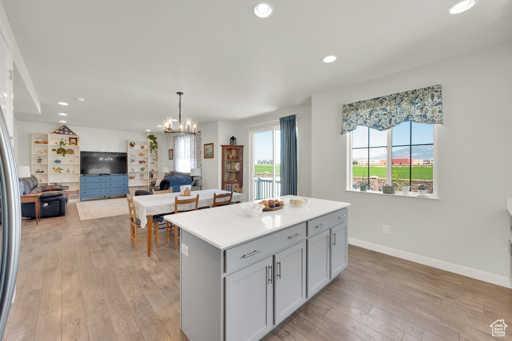 Kitchen featuring light wood-style flooring, a center island, recessed lighting, light countertops, and a chandelier