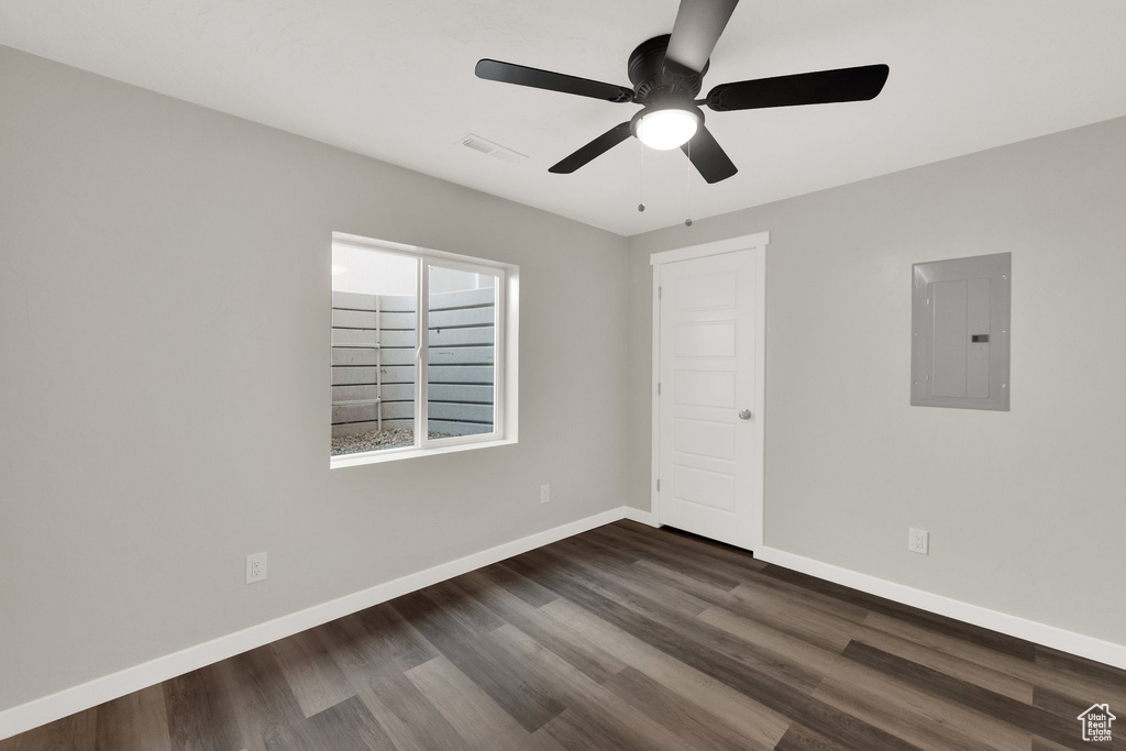 Unfurnished room featuring electric panel, dark wood finished floors, and a ceiling fan