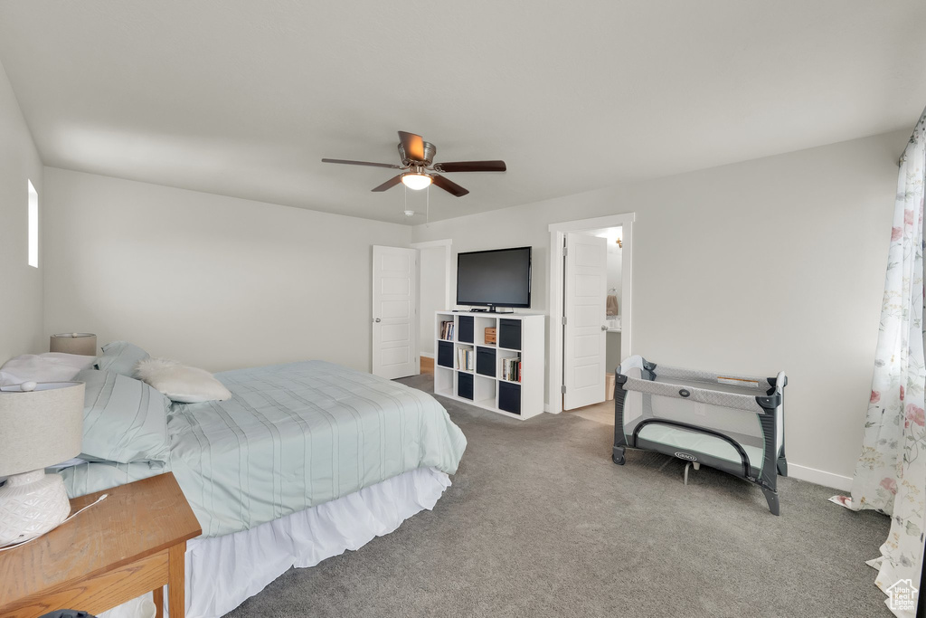 Carpeted bedroom featuring ceiling fan and baseboards