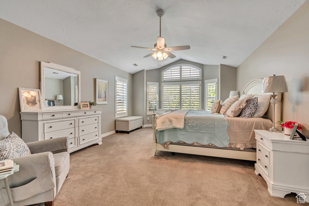 Bedroom featuring vaulted ceiling, light carpet, and ceiling fan